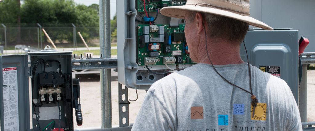 Donard Metzger inspects power connections at a test PV installation.