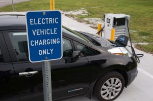 Electric vehicle charging only sign with Nissan LEAF and charging station