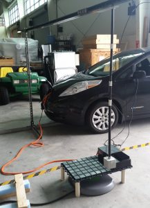 Nissan Leaf undergoing a wireless charging test in high bay workshop.