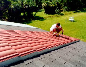 FSEC engineer John Sherwin color matches a condensation sensor installed on the red tile roof.