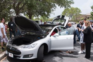 Gray Tesla electric car with all doors and hood opened for workshop participants to take a look.
