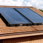 Two solar water heating panels on brown single roof.