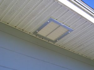 Mechanical vent under roof soffit of house, photo.