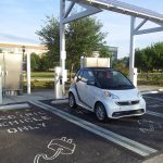 Electric vehicle charging at charging station under photovoltaic array onUCF Orlando campus