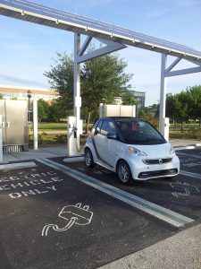 Electric vehicle charging at charging station under photovoltaic array onUCF Orlando campus