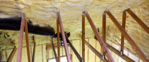 View from attic rafters of yellow, spray foam insulation