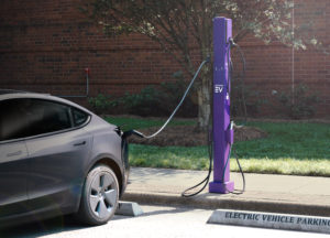 Atom Power EV charging station (purple), charging gray colored Tesla.